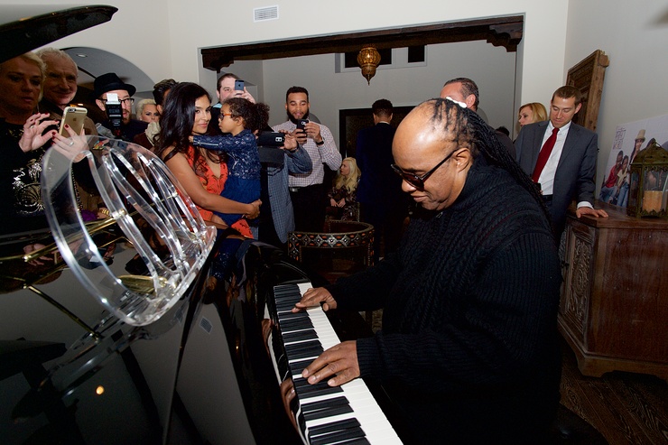 Stevie Wonder brings everyone together around the piano.