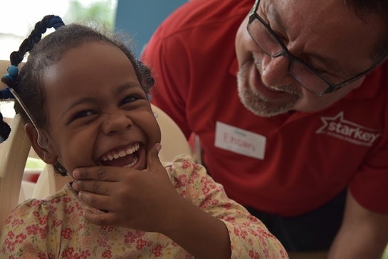 A young girl in the Dominican Republic celebrates hearing for the first time with Bayat Foundation Chairman Ehsan Bayat