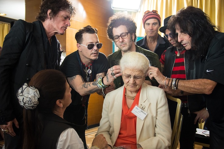 Joe Perry, Johnny Depp, Bruce Witkin, Robert DeLeo, Tommy Henriksen and Alice Cooper of the Hollywood Vampires install an hearing aid on a patient of the Starkey Hearing Foundation