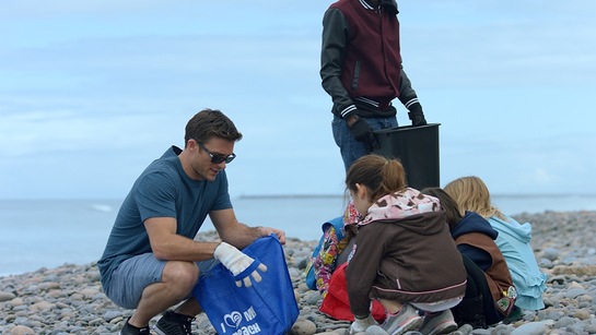 Scott Eastwood with volunterring children at Surfrider beach cleanup