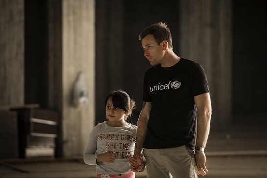 Ewan McGregor walks with Myrna, 10, inside an abandoned mall that her and her family used to live in, Erbil, northern Iraq