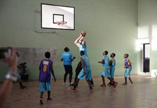 Dikembe Mutumbo goes for a basket while playing with local players at a school in Maputo, Mozambique.