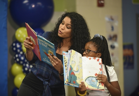 Jordin Sparks reads with a student from Amidon-Bowen Elementary School during Reading Is Fundamental's 50th Anniversary