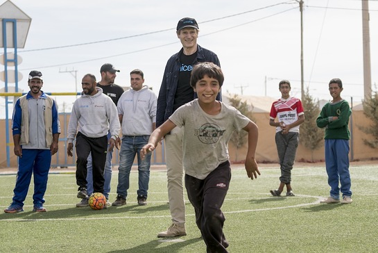 Liam Neeson plays football during a visit to a Makani centre in Za'atari refugee camp in Jordan