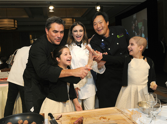 Chef Todd English, singer Daya, and chef Ming Tsai, left to right, with twins Sabrina and Olivia Lorusso, front, celebrate at Family Reach's Cooking Live! charity event