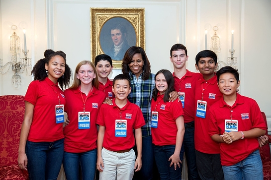 Michelle Obama joins Scholastic News Kid Reporters for a group photo following an interview in the Map Room of the White House