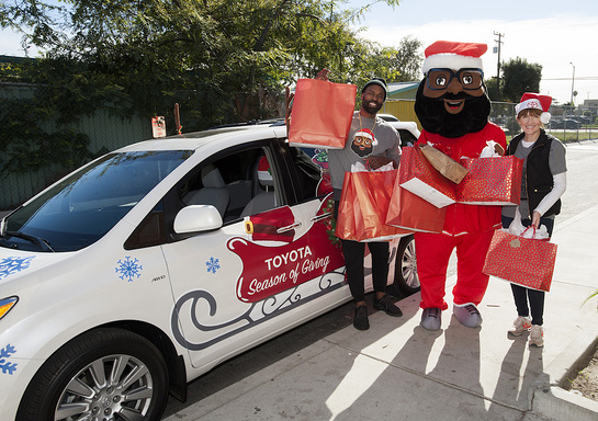 Baron Davis and the Black Santa Mascot arrive at the Boys and Girls Club of Watts in a decorated Toyota Sienna filled with gifts!