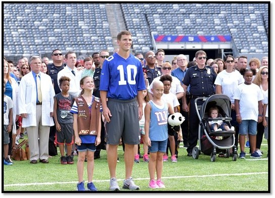 Eli Manning stands with doctors, nurses, team members, patients and families from Hackensack University Medical Center as a part of the Tackle Kids Cancer campaign