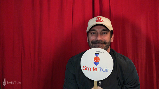 Jon Hamm shows off a Smile Train fan backstage at the Eighth Annual Pardcast-a-Thon