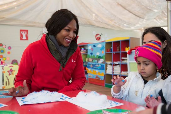 Naomi Campbell participates in a finger painting class with 4-year-old Yara at Save the Children's Sunshine Kindergarten