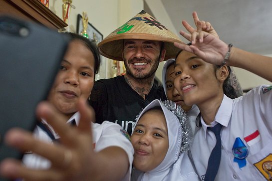 David Beckham poses with students at the SMPN 17 school in Semarang, Indonesia