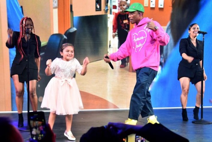 Pharrell Williams performs onstage with CHLA patient Eliana Georges