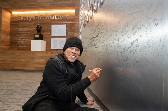 Smokey Robinson signs the autograph wall at St. Jude Children's Research Hospital in Memphis