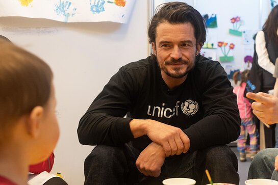 Orlando Bloom talks to children at Moldexpo centre in Moldova