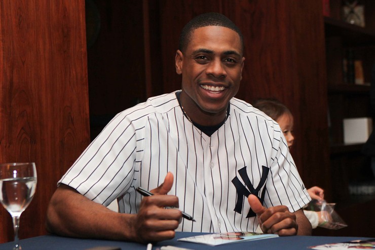 Curtis Granderson poses while signing photos for fans.