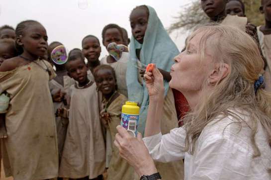 Mia Farrow blows soap bubbles to the delight of children at the Zam Zam camp for people displaced by the conflict in Darfur.