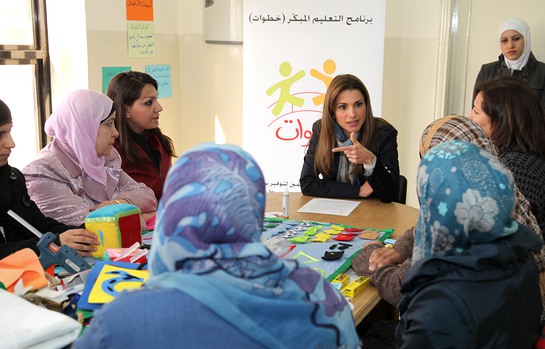 Mothers show Queen Rania some of the learning materials they learned how to make.