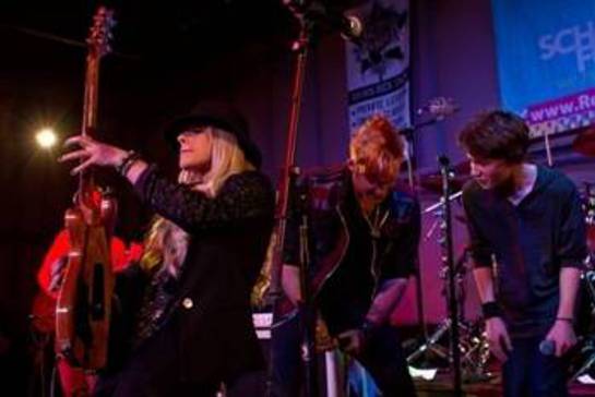 In this photo, Orianthi (left) is shredding while James Durbin (center) rocks out with one of the students.