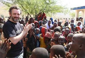 Michael Sheen sings and plays with children next to a rural health centre in Chad supported by UNICEF