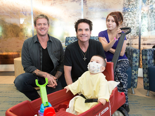 Members of the Grammy-award winning group, Train, visit with Denver Health patient, Elijah (1 year old) and his mother, Devonie before performing at the hospital's annual gala.