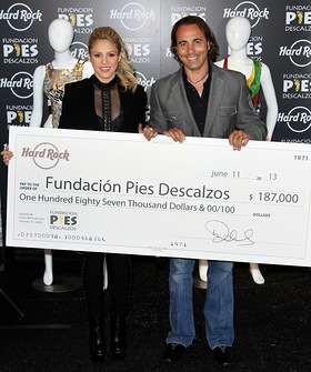 Area Vice President at Hard Rock International, Tom Perez, poses with Fundación Pies Descalzos Founder and singer, Shakira to present a check of over $185,000 towards Pies Descalzos
