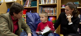 Jennifer Garner and Mark Shriver read with a child participating in Save the Children's early education program