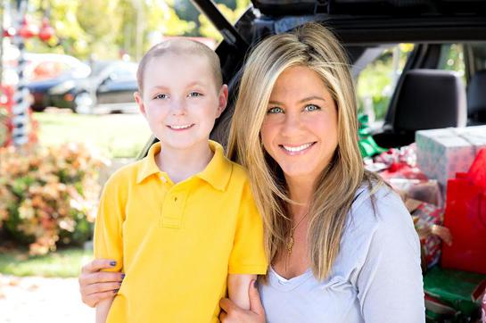 St. Jude Thanks and Giving celebrity supporter Jennifer Aniston smiles alongside St. Jude patient Cash