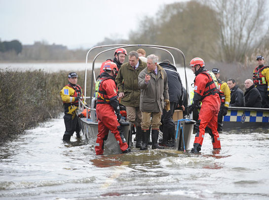 The Prince of Wales steps from a boat after travelling to the flood-hit community of Muchelney