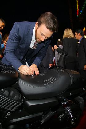 Chris Evans signs a new Harley-Davidson Street 750 at the premiere in Hollywood, CA.