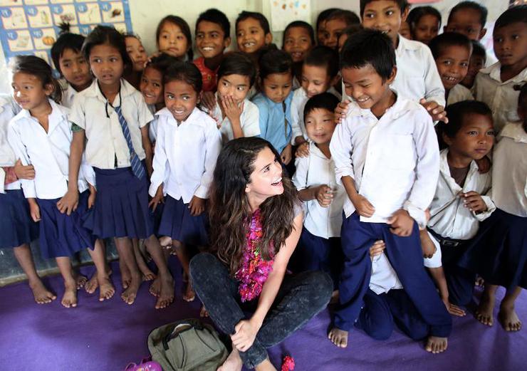 UNICEF Ambassador, Selena Gomez enjoys a sweet moment with a student while the early childhood education class gathers for a group photo at Satbariya Rapti Secondary School