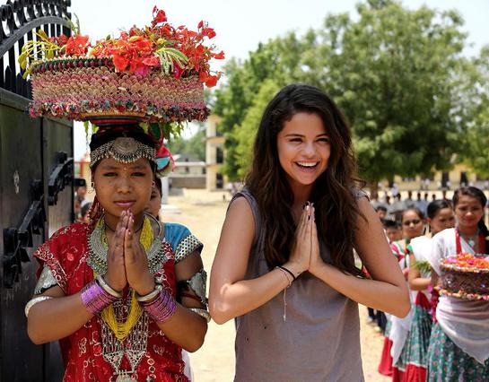 Selena Gomez is greeted by students at Satbariya Rapti Secondary School wearing traditional Nepali clothing