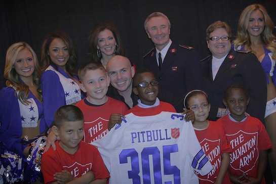 Pitbull was joined by the Dallas Cowboys cheerleaders Friday during his concert in Dallas to announce that he will kickoff The Salvation Army Red Kettle Campaign