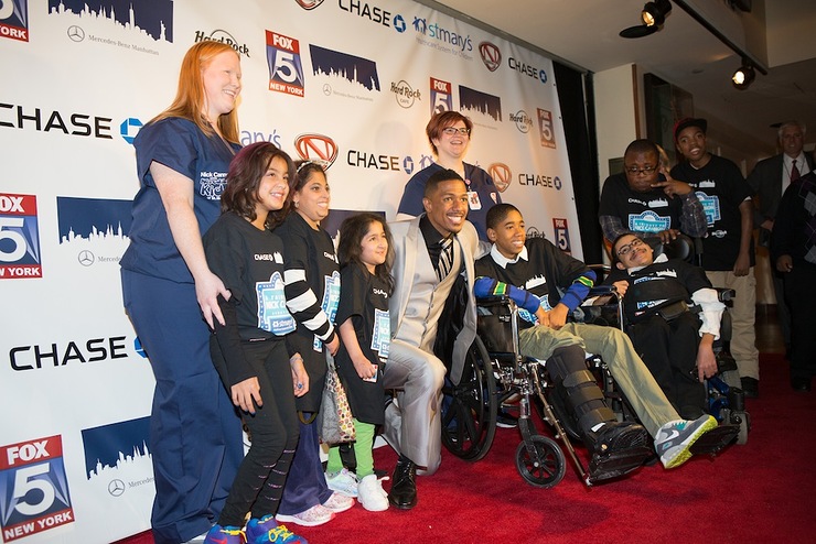 Nick Cannon poses on the red carpet at Hard Rock Cafe in Times Square with children and staff from St. Mary’s Children’s Hospital