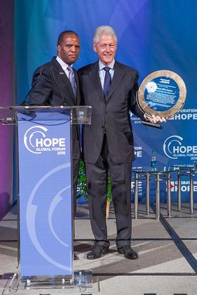 Operation HOPE Founder John Hope Bryant presents award to President Bill Clinton at the 2015 HOPE Global Forum