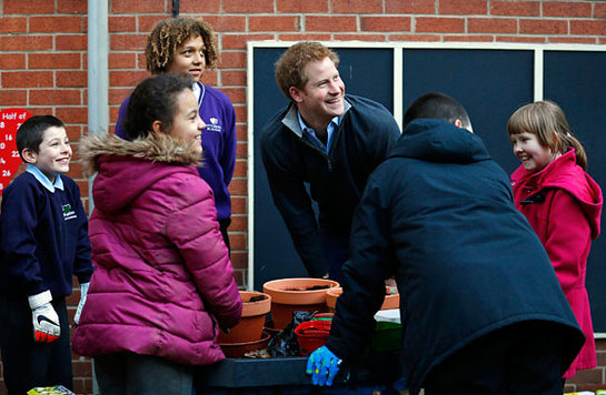 Prince Harry laughs with youngsters involved in a garden project during a visit to the Full Effect Youth Projec