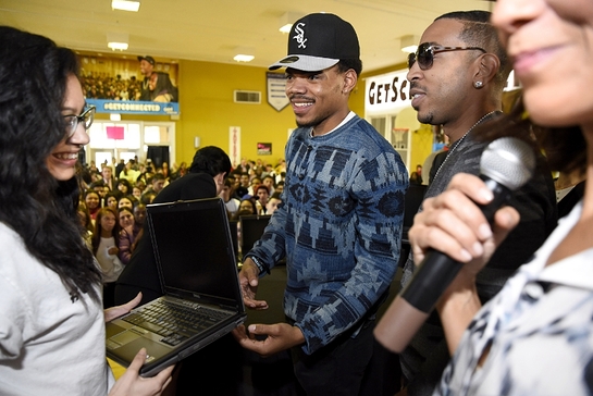 Chance the Rapper and Ludacris present a new Internet Essentials laptop to an Alcott College Prep student for the Get Schooled, Get Connected Spring Challenge.