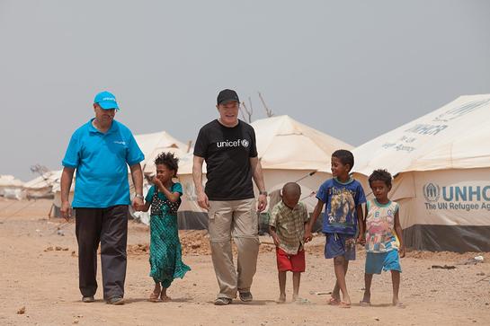 Eddie Izzard and UNICEF Djibouti Deputy Representative Moncef Moalla with refugees from Yemen