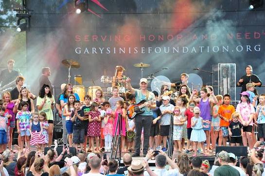 Gary Sinise was joined on stage by the young children of the troops at Fort Belvoir during the USO-Metro Invincible Spirit Festival