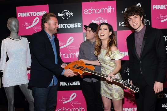 James Buell, left, Senior Director of Music and Marketing for Hard Rock International, accepts a signed guitar from Echosmith
