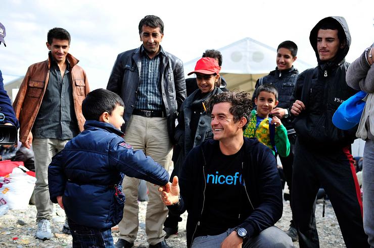 Orlando Bloom greets a child at the refugee and migrants reception centre near the town of Gevgelija, close to the border with Greece.