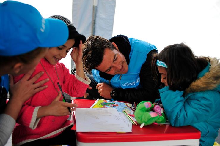 Orlando Bloom greets children in a child-friendly space at the refugees and migrants one stop registration centre in the town of Presevo in south Serbia